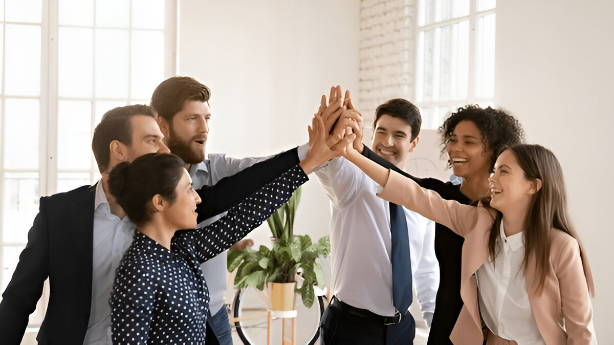 Cheerful multiethnic team of young professionals giving group high five, enjoying teamwork spirit, celebrating job success, achievement, win, successful cooperation, shouting for joy.